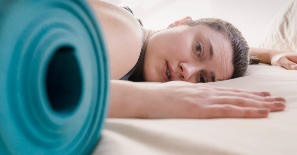 ヨガポーズがうまくできず悩む女性が、柔軟性や筋力の壁に直面している様子